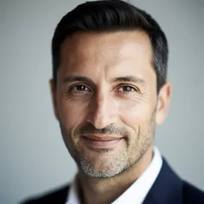 Portrait of a French man in his early 40s, short dark hair, light stubble, soft natural lighting, neutral background, realistic professional headshot, shallow depth of field
